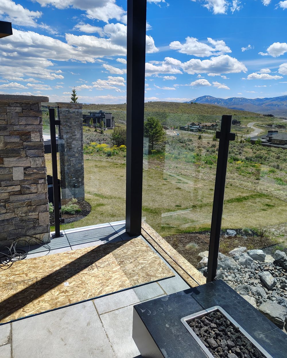 Glass-rail patio edge on a job site overlooking a Utah valley